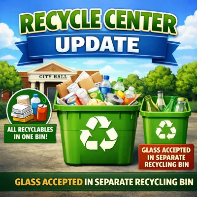 Graphic titled “Recycle Center Update” showing City Hall in the background and two green recycling bins in front. The larger bin is filled with mixed recyclable materials and labeled “All recyclables in one bin!” The smaller bin contains glass bottles and jars with text stating “Glass accepted in separate recycling bin.” A banner across the bottom repeats: “Glass accepted in separate recycling bin.”